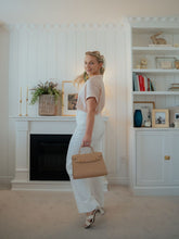 A blonde lady wears a pair of pants